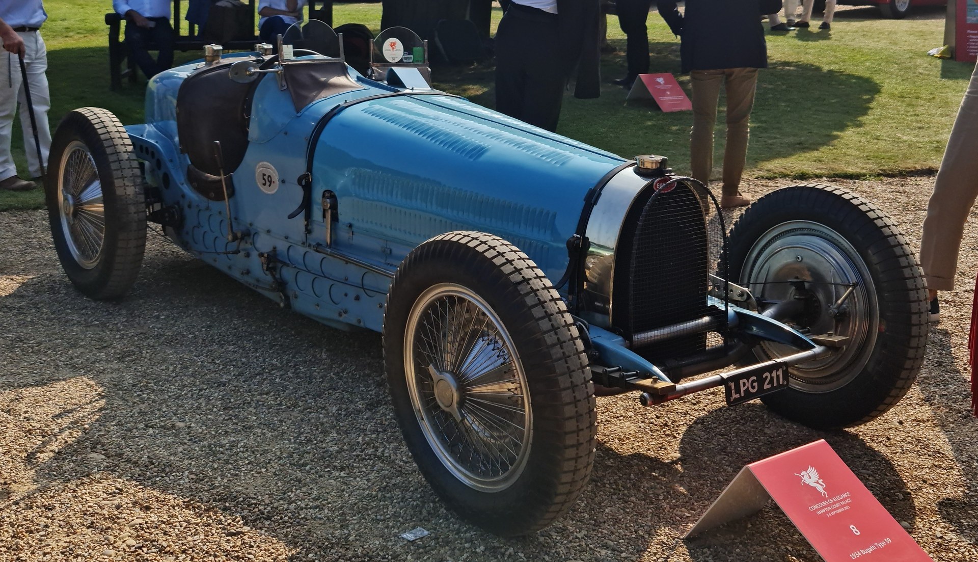 Light blue 1934 Bugatti Type 59 Grand Prix car parked on gravel at a concours