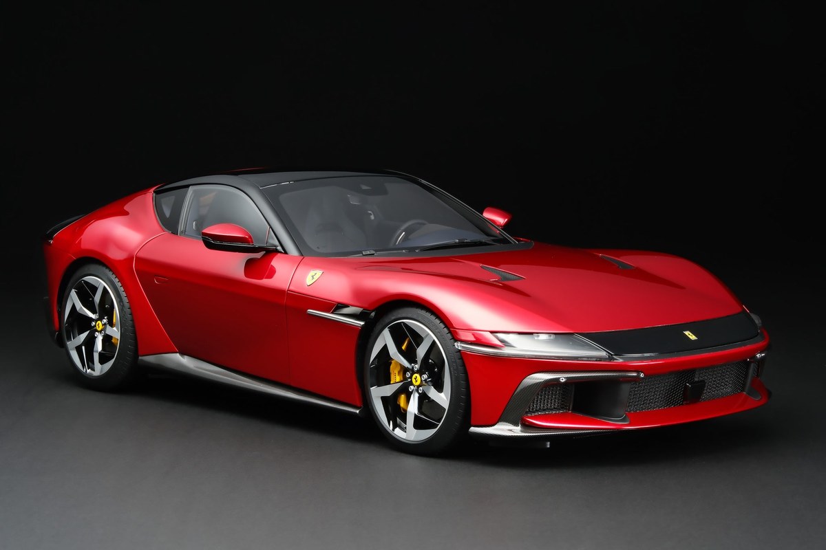 The 1:8 scale Amalgam Ferrari 12Cilindri in Rosso Imola photographed in a studio, three-quarter front view, capturing the V12 grand tourer's proportions, paint finish and wheel detail