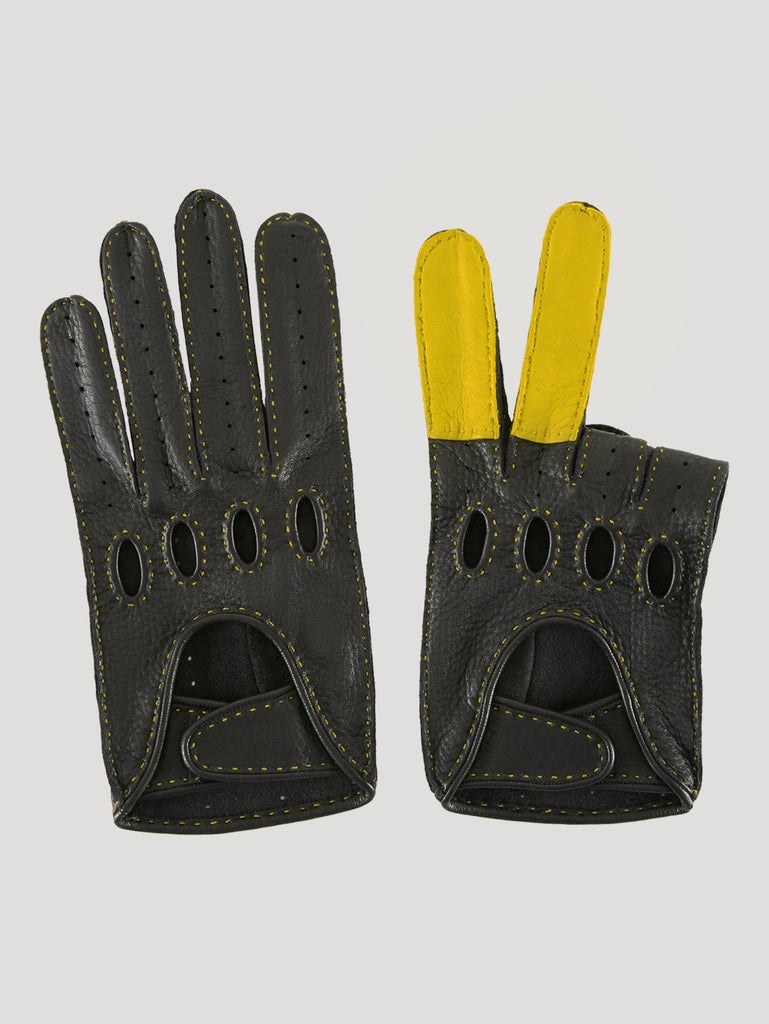The Connolly Road Rage driving glove in black deerskin with yellow detailing, photographed flat, showing the cut-out knuckle holes and perforated fingers