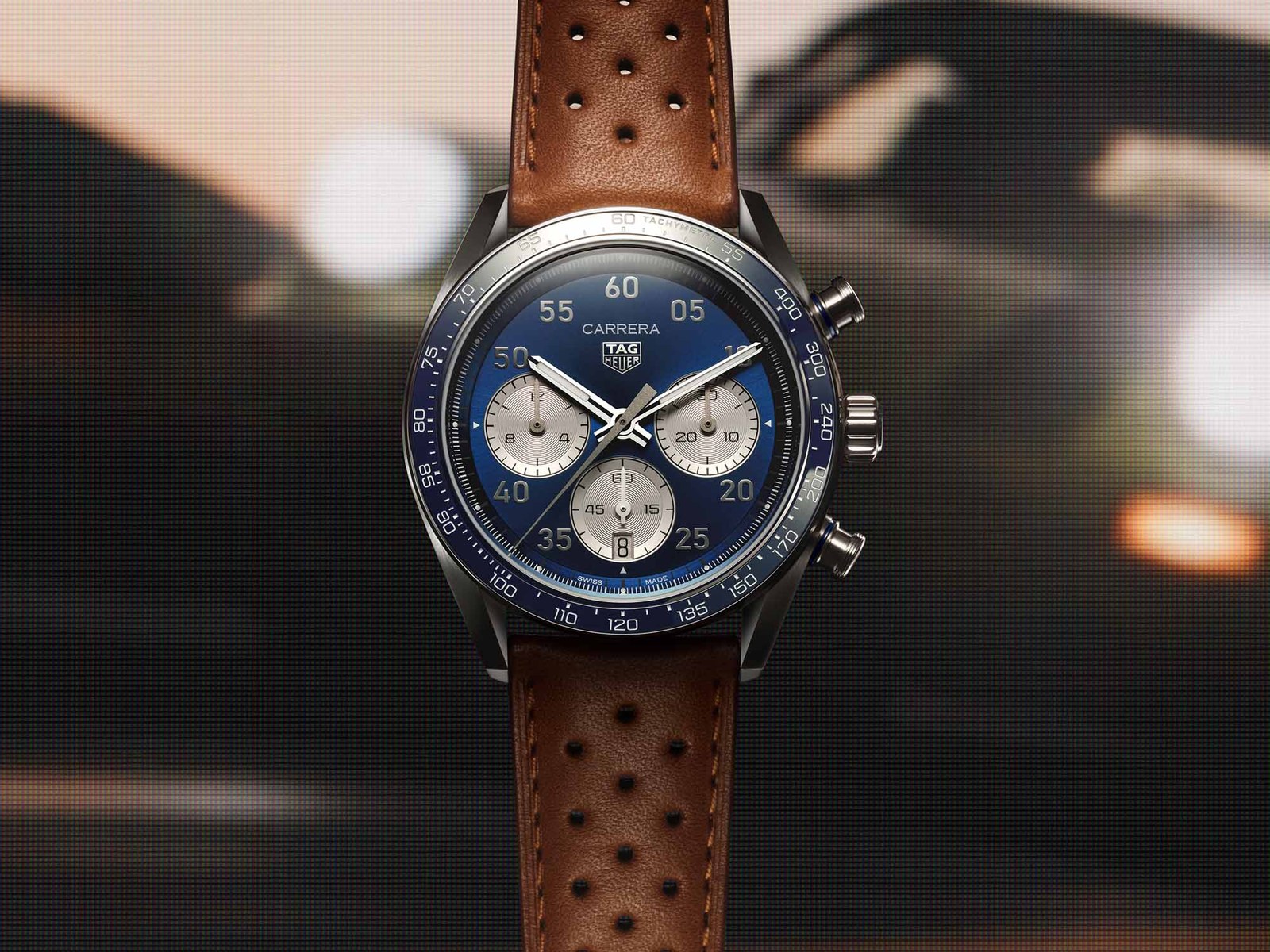 The 2026 TAG Heuer Carrera Chronograph Sport with blue sunray dial and silver subdials on a perforated brown leather strap, photographed front-on