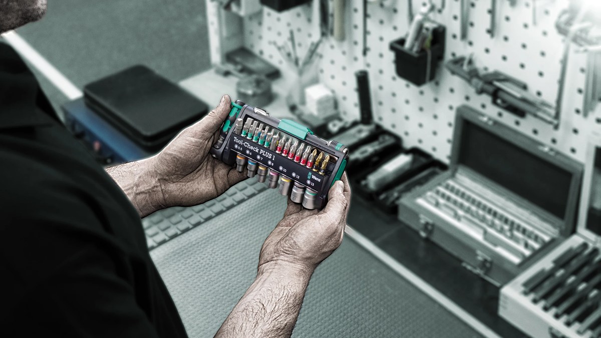 The Wera Tool-Check PLUS 1 open in its compact case, the 1/4 inch bit ratchet, seven sockets and the colour-coded BiTorsion bits arranged in their locking holders, photographed from above on a workbench