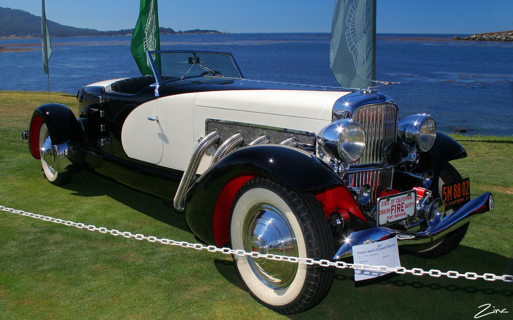 Black and cream 1933 Duesenberg J Weymann boattail speedster on the Pebble Beach Concours lawn by the sea