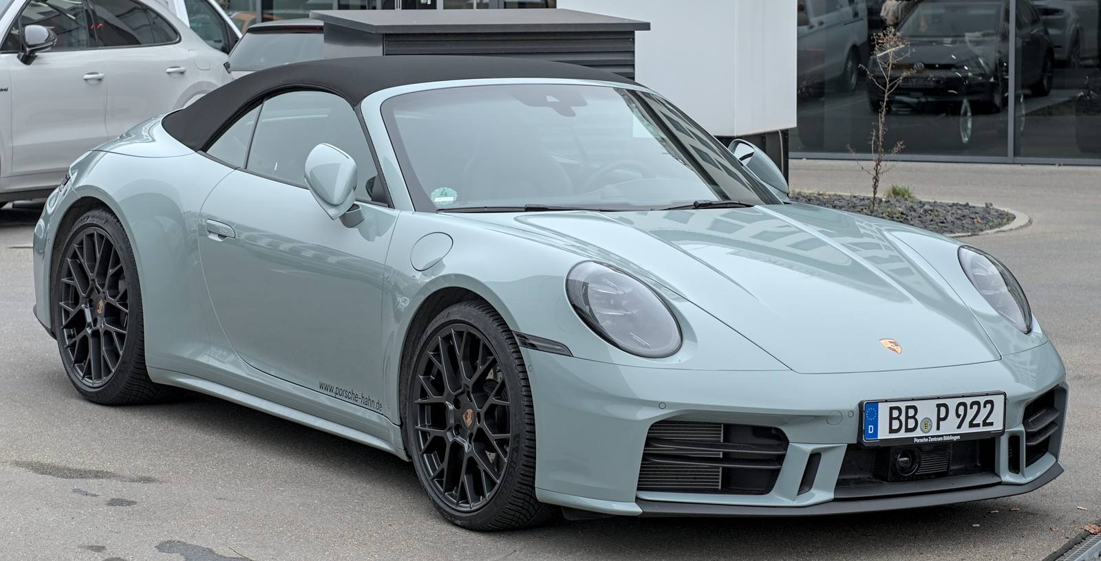 Light grey 2025 Porsche 992 Carrera convertible, front three-quarter view, in Böblingen